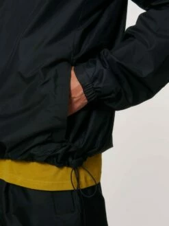 Unisex Windbreaker Aus Recyceltem Polyester - Black -Grundstoff Verkaufsladen U846 002 10 Detail Gummibund im Saum durch Stopper verstellbar elastisches Buendchen im Aermel Seitentasche mit Reissverschluss 1280x1280