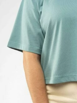 Mela Fairtrade Cropped T-Shirt Jandra Aus Bio-Baumwolle - Turquoise -Grundstoff Verkaufsladen jandra tur 04 Bio Baumwoll Shirt mit ueberschnittenen laengeren Aermeln fair und nachhaltig 1280x1280